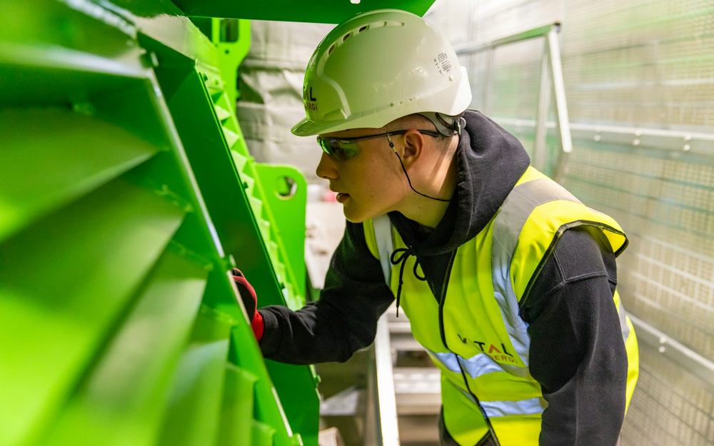 Worker at height in a hard hat and safety harness on a structure