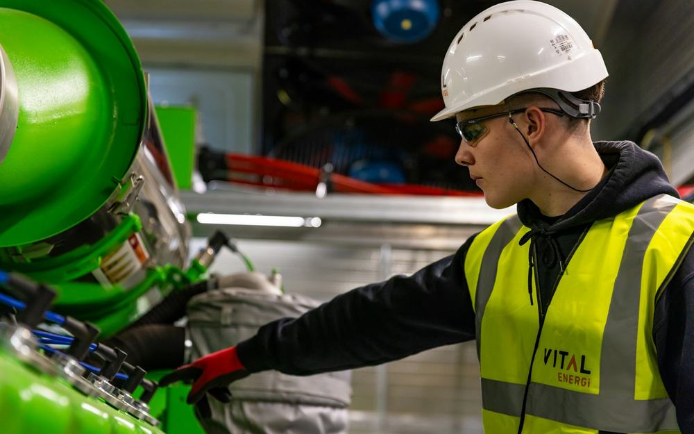 Factory technician operating machinery in protective gear